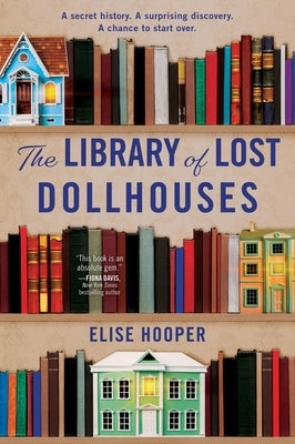 Paperback copy of The Library of Lost Dollhouses by William Morrow & Company, showing the book cover with vintage dollhouse illustrations.