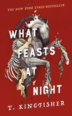 Paperback copy of "What Feasts at Night" by Tor Nightfire, featuring a dark, atmospheric cover with haunting imagery.