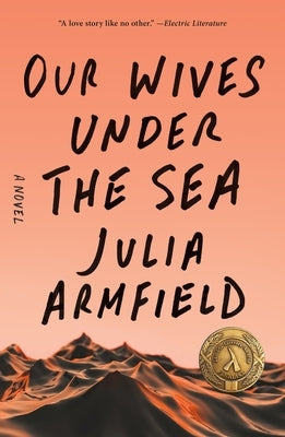 Paperback copy of "Our Wives Under the Sea" by Flatiron Books, featuring the book cover with dark, atmospheric artwork.