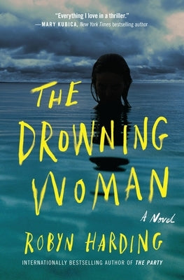 Paperback of The Drowning Woman novel by Grand Central Publishing, showing the book cover with dark and moody artwork.