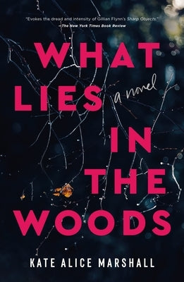 Paperback copy of "What Lies in the Woods" by Flatiron Books showing the book cover with dark forest imagery.