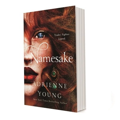 Paperback of Namesake by Wednesday Books featuring a close-up of the book cover with artistic design and title text.