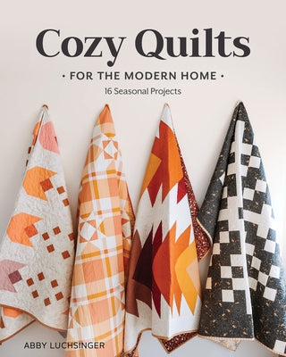 Paperback book titled "Cozy Quilts for the Modern Home" by Stash Books, featuring colorful quilt patterns on the cover.