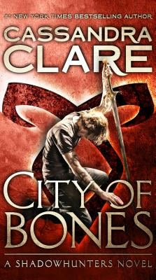 Mass market paperback of "City of Bones" by Cassandra Clare, published by Pocket Books, showing the book cover with cityscape art.