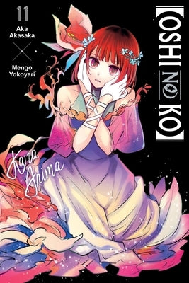 Paperback of Oshi No Ko Volume 11 by Yen Press, showing the front cover with colorful manga artwork.