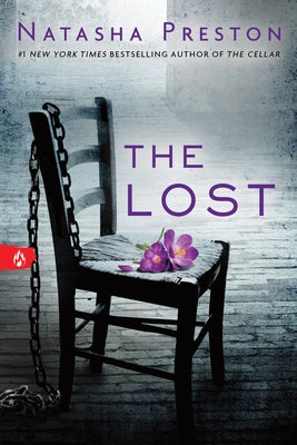 Paperback copy of "The Lost" by Sourcebooks Fire featuring a book cover with dark, mysterious artwork.