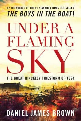 Paperback copy of "Under a Flaming Sky" by Lyons Press, showing the book cover with fiery imagery and historical firestorm scene.