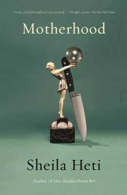 Paperback copy of Motherhood book by Picador USA, featuring the cover with title and author’s name on a plain background.