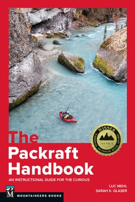 Paperback copy of The Packraft Handbook by Mountaineers Books, featuring a cover image with outdoor adventure illustrations.