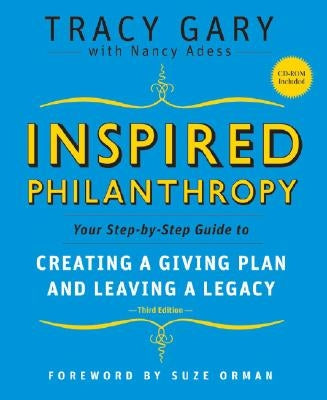Paperback book titled "Inspired Philanthropy" by Jossey-Bass, featuring a cover with a gift box and a pen, on a wooden surface.