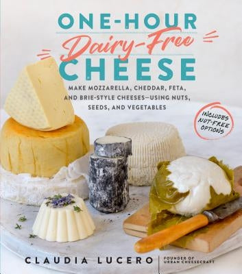 Paperback cookbook showing colorful pages with dairy-free cheese recipes made from nuts, seeds, and vegetables.