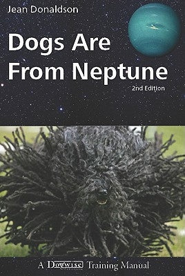 Paperback copy of "Dogs Are from Neptune" by Dogwise Publishing with a colorful cover featuring playful dog illustrations.