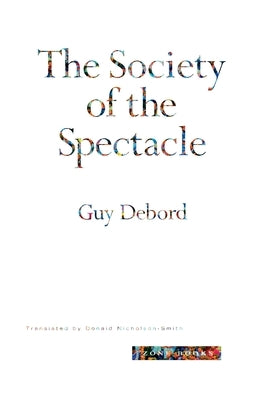 Paperback copy of The Society of the Spectacle by Zone Books, featuring a cover with abstract artwork and text.