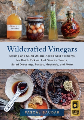 Paperback book titled "Wildcrafted Vinegars" by Chelsea Green Publishing, featuring colorful pages on making and using acetic acid ferments.