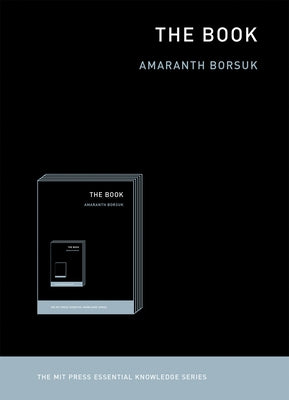 A hardcover copy of "The Book" by MIT Press with an abstract cover design, resting on a wooden surface.