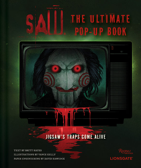 Paperback of "Saw: The Ultimate Pop-Up Book" by Rizzoli Universe featuring colorful jigsaw trap illustrations on the cover.