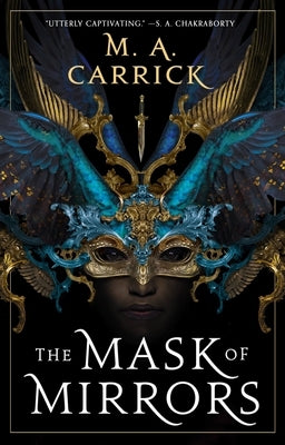 Paperback copy of The Mask of Mirrors novel by Orbit, featuring cover art with mystical and intricate design elements.
