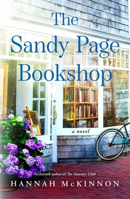 Paperback book titled "The Sandy Page Bookshop" by Atria Books, with a close-up of the book cover featuring a sandy beach scene.