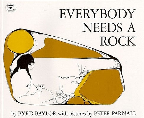 Paperback copy of "Everybody Needs a Rock" by Aladdin Paperbacks, showing the book cover with colorful illustrations.