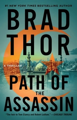 Paperback copy of "Path of the Assassin: A Thriller" by Atria Books, featuring a cover image with dark, intense artwork.