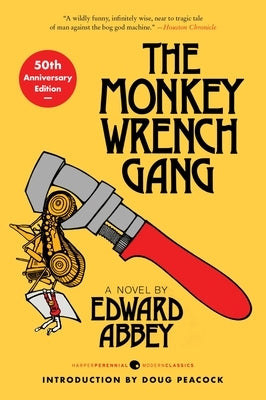 Paperback copy of The Monkey Wrench Gang 50th Anniversary Edition by Harper Perennial, featuring the book cover with bold title and artwork.