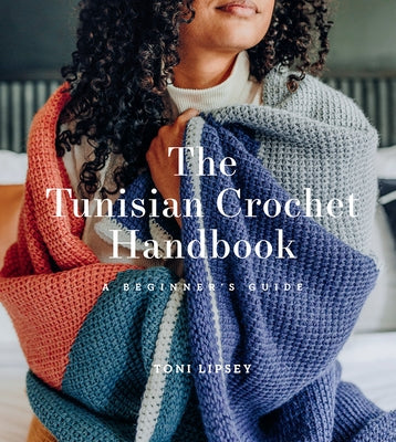 Paperback copy of The Tunisian Crochet Handbook by Harry N. Abrams, featuring a colorful cover with crochet tools and yarn.