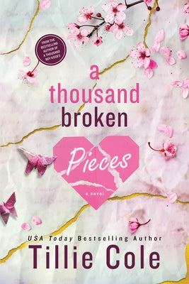 A paperback copy of "A Thousand Broken Pieces" by Bloom Books, featuring a cover with artistic design and book title.