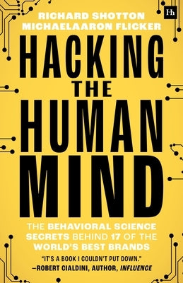 Paperback book titled "Hacking the Human Mind" by Harriman House, featuring a cover with a brain and behavioral science imagery.