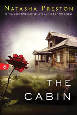 Paperback copy of "The Cabin" novel by Sourcebooks Fire, showing the book cover with title and design details.