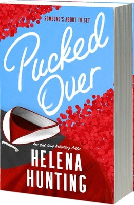 Paperback of "Pucked Over" by Entangled: Amara, showing the book cover with colorful artwork and title text.