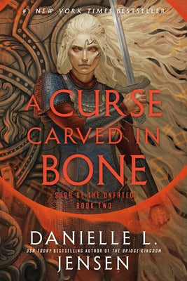 Paperback copy of "A Curse Carved in Bone," Book Two of the Saga of the Unfated, featuring dark, detailed cover art by Del Rey Books.