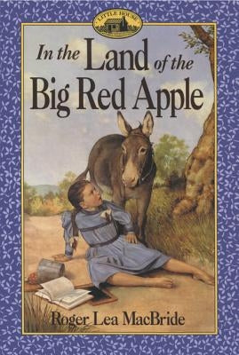 Paperback copy of "In the Land of the Big Red Apple" by HarperCollins, featuring colorful cover art of a big red apple.