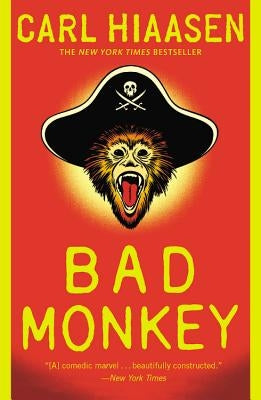 Paperback copy of Bad Monkey novel by Grand Central Publishing, featuring a colorful cover with a humorous illustration.