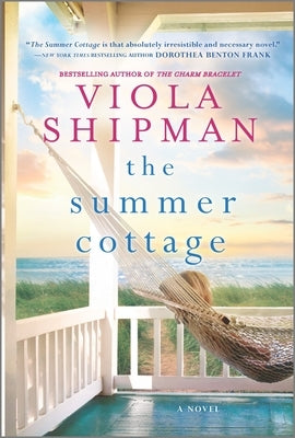 Paperback copy of The Summer Cottage novel by Graydon House, showing the book cover with a scenic summer cottage image.