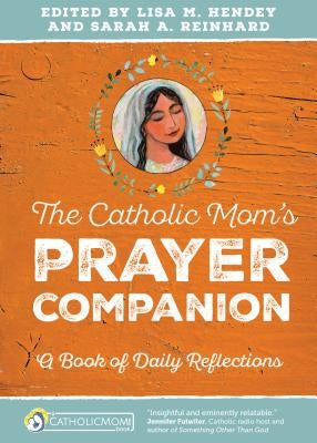 Open book titled The Catholic Mom's Prayer Companion by Ave Maria Press featuring daily reflections and prayer prompts.