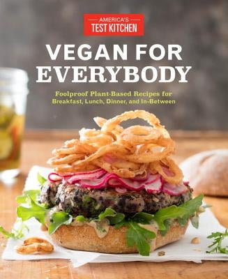 Paperback cookbook titled Vegan for Everybody by America's Test Kitchen featuring colorful plant-based recipes for all meals.