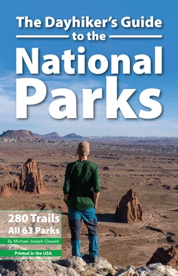 Paperback copy of The Dayhiker's Guide to the National Parks by Stone Road Press, featuring a cover image with park trail illustrations.