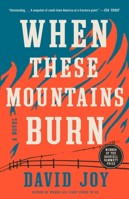 Paperback copy of "When These Mountains Burn" by G.P. Putnam's Sons, showing the book cover with mountain landscape artwork.