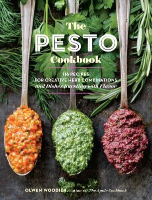 Paperback cookbook titled "The Pesto Cookbook" featuring colorful images of pesto dishes and fresh herbs on the cover.